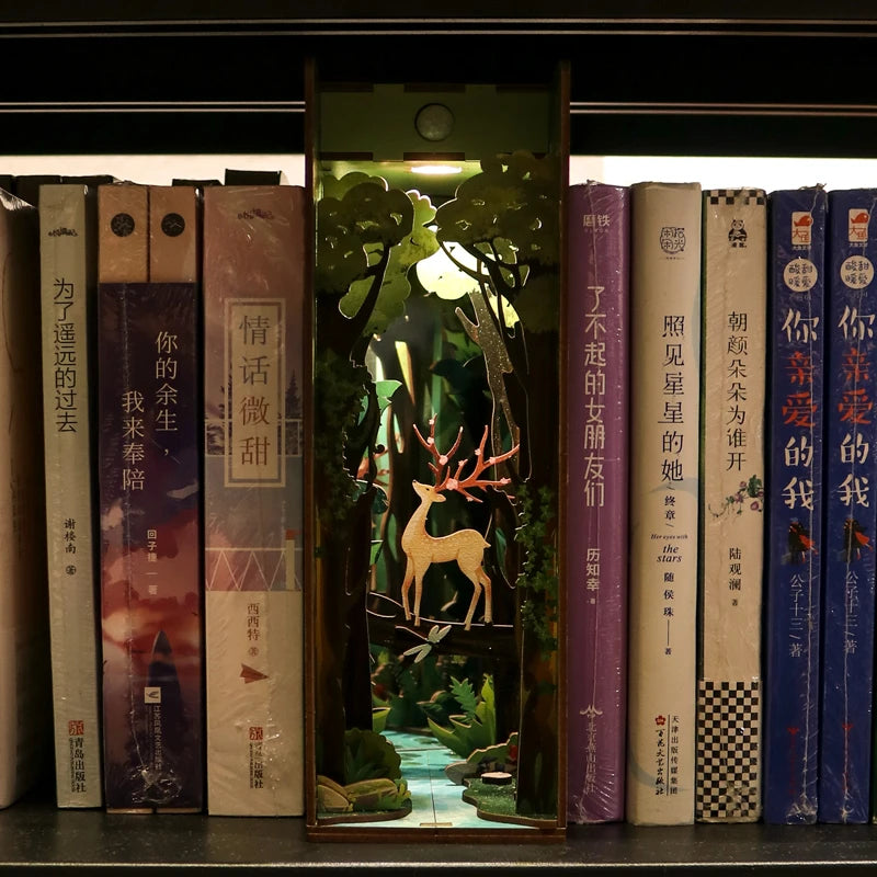 Illuminated book nook with forest and deer on bookshelf